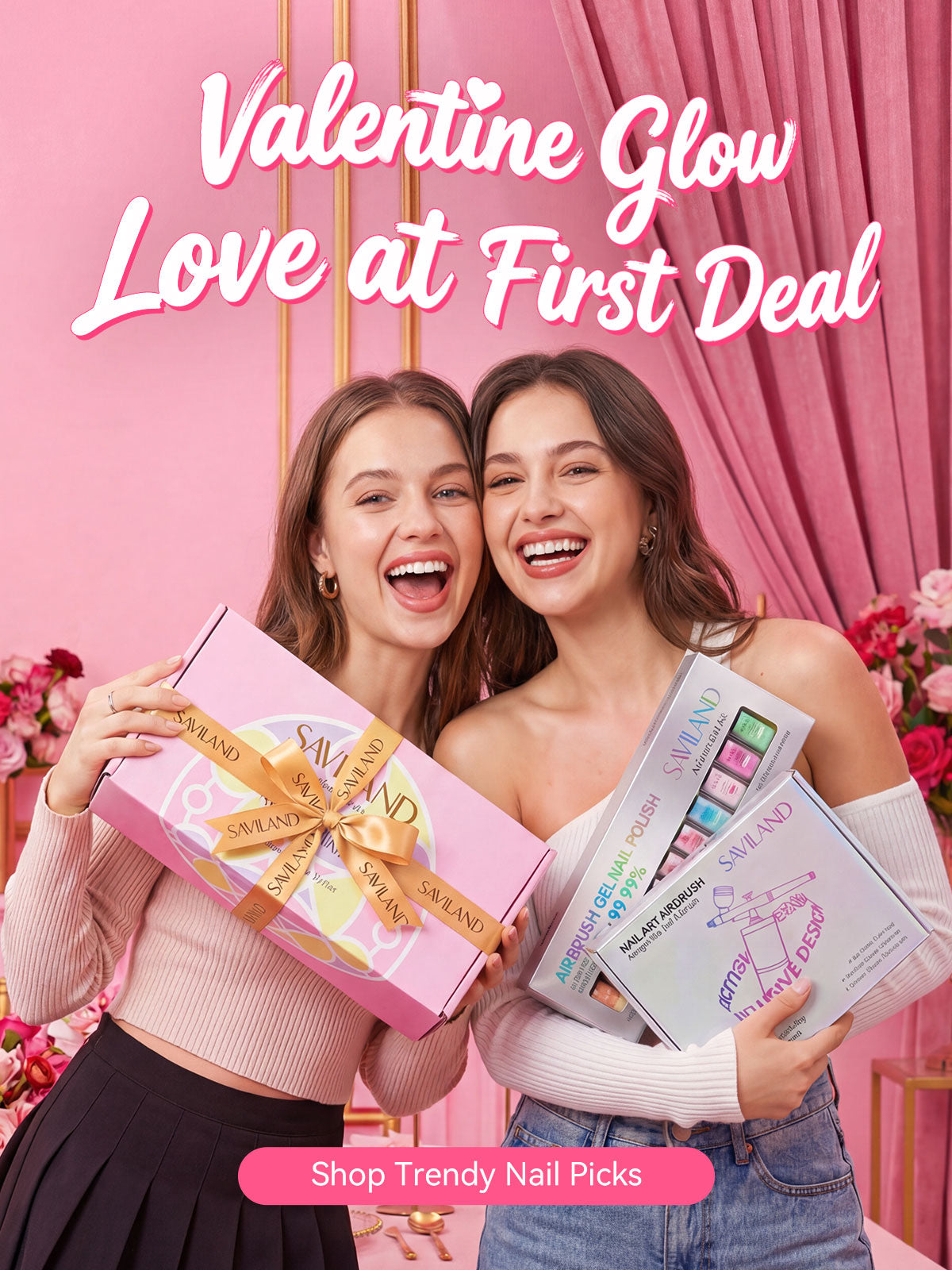 Two women smiling while holding SAVILAND Valentine’s Day nail gift sets in a pink romantic setting